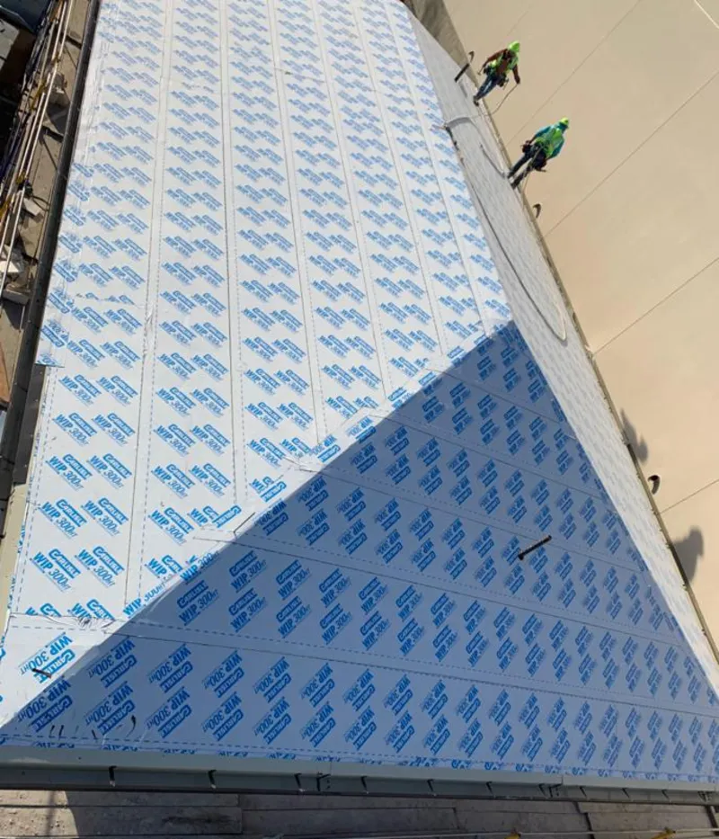 Professional roofers installing underlayment on a metal roof in East Bay